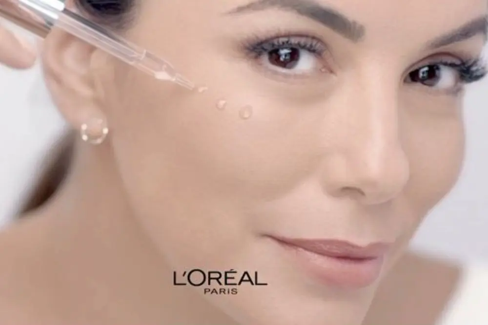 Modelo aplicando gotas do Sérum L'Oréal Paris Revitalift Hialurônico diretamente no rosto.