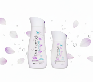 Duas embalagens do sabonete íntimo Dermacyd Pro-bio Delicata (200ml e 100ml) centralizadas em um fundo branco limpo, com pétalas de flores lilás e bolhas de água suaves flutuando ao redor, em formato horizontal para destaque de blog.