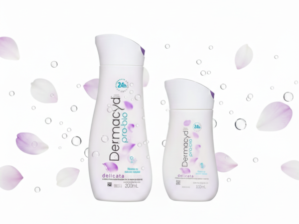 Duas embalagens do sabonete íntimo Dermacyd Pro-bio Delicata (200ml e 100ml) centralizadas em um fundo branco limpo, com pétalas de flores lilás e bolhas de água suaves flutuando ao redor, em formato horizontal para destaque de blog.