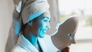 Mulher usando máscara de LED facial durante a rotina de skincare.