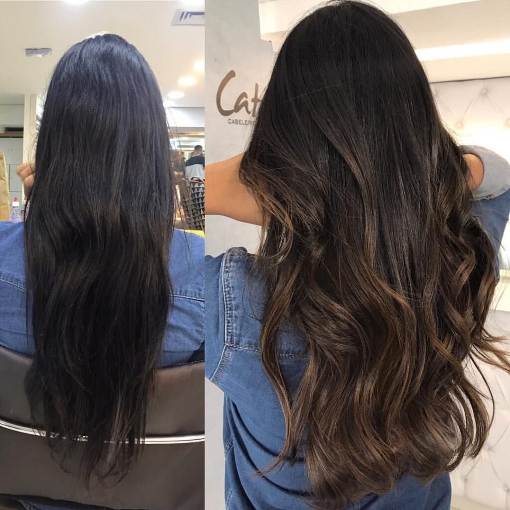 Cabelo longo e ondulado com técnica morena iluminada em tons de mel e avelã, apresentando brilho intenso e pontas saudáveis.