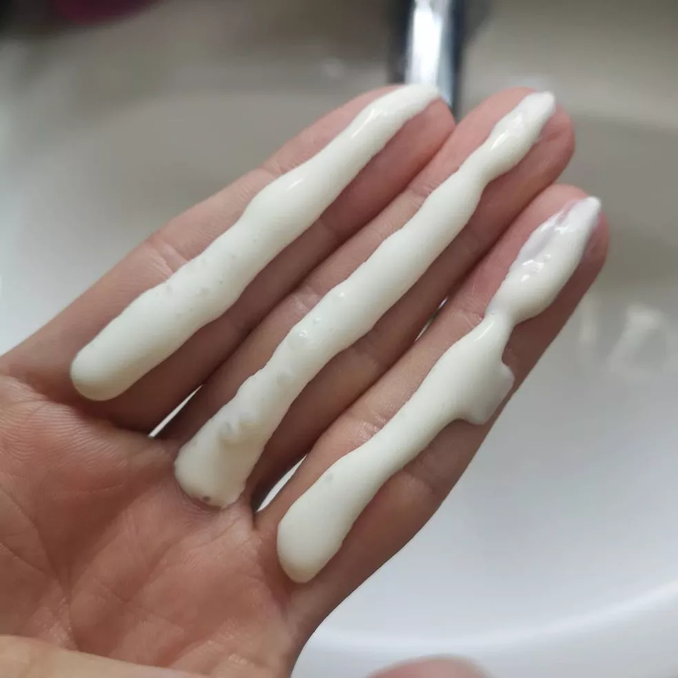 Aplicação correta de protetor solar usando a regra dos três dedos para máxima proteção facial.