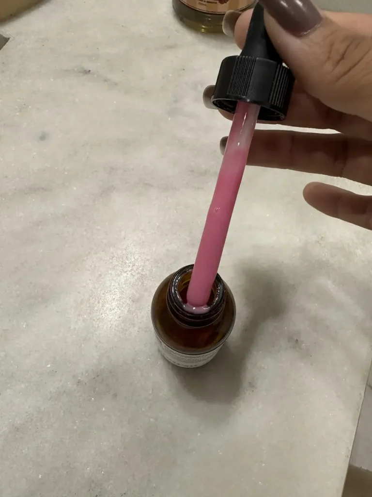 Close do conta-gotas mostrando a cor rosa e a textura do Sérum Principia Mix-03