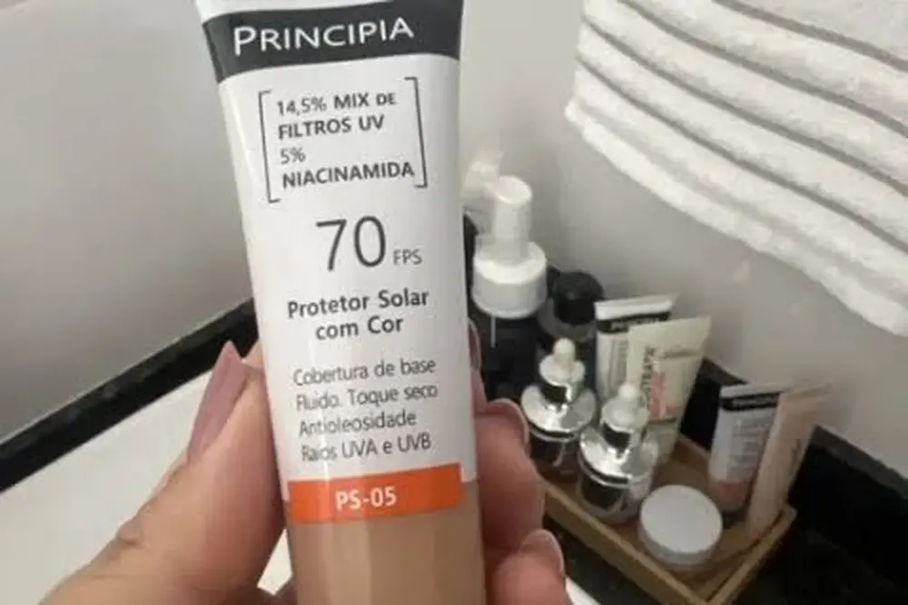 Protetor Solar Principia PS-05 com cor sendo segurado na mão